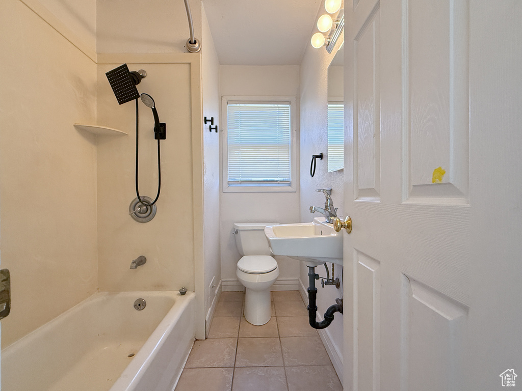 Bathroom with toilet, tub / shower combination, and tile patterned flooring