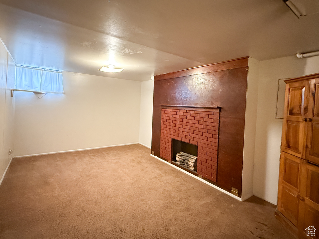 Finished basement featuring carpet floors and a brick fireplace