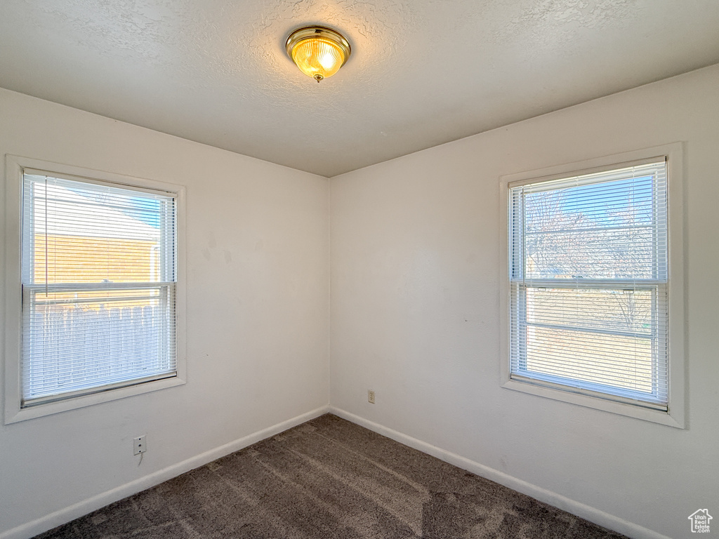Spare room featuring a textured ceiling and carpet flooring