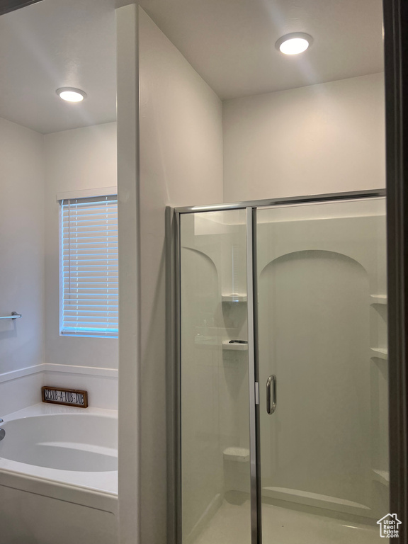 Bathroom featuring shower with separate bathtub