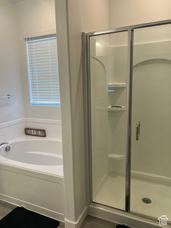 Bathroom featuring wood-type flooring and plus walk in shower