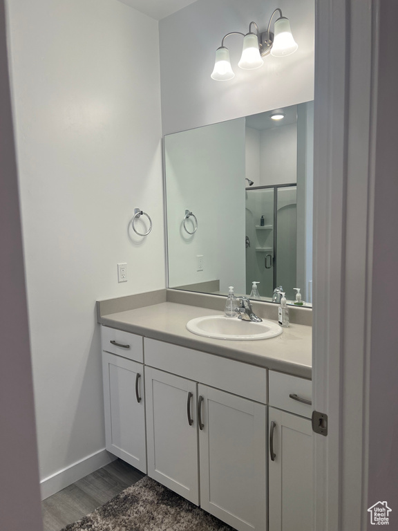 Bathroom featuring vanity, a shower with shower door, and hardwood / wood-style floors