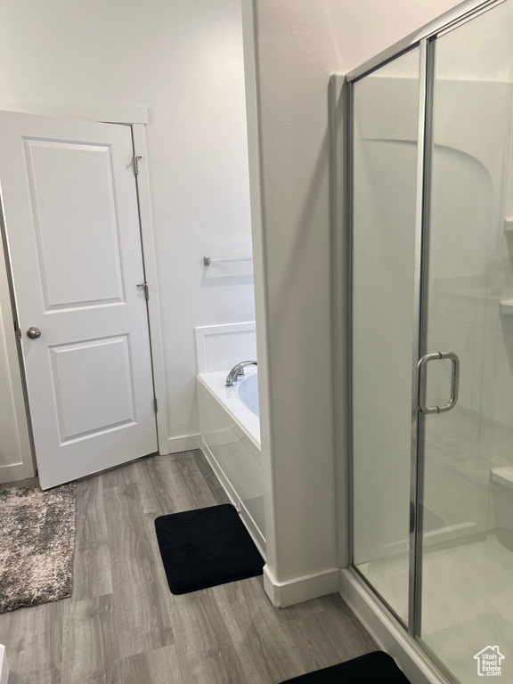 Bathroom featuring hardwood / wood-style flooring and independent shower and bath