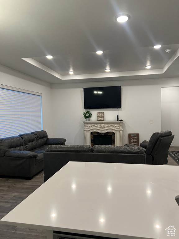 Living room featuring dark wood-type flooring and a tray ceiling