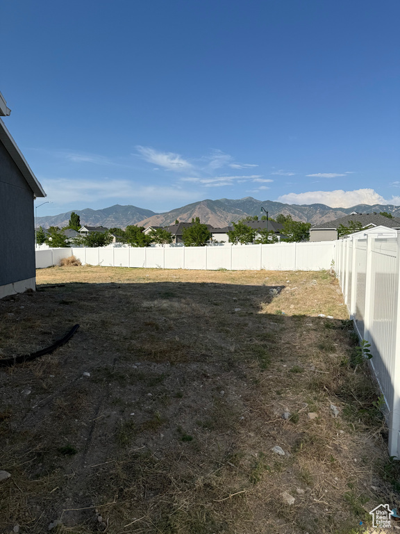 Fenced backyard featuring a mountain view