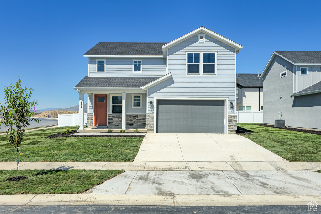 View of front of home with cooling unit, an attached garage, driveway, roof with shingles, and stone siding