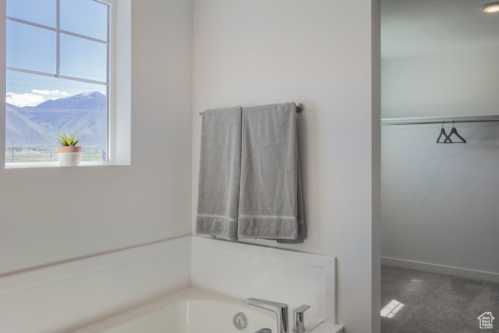 Full bath featuring a garden tub and a mountain view