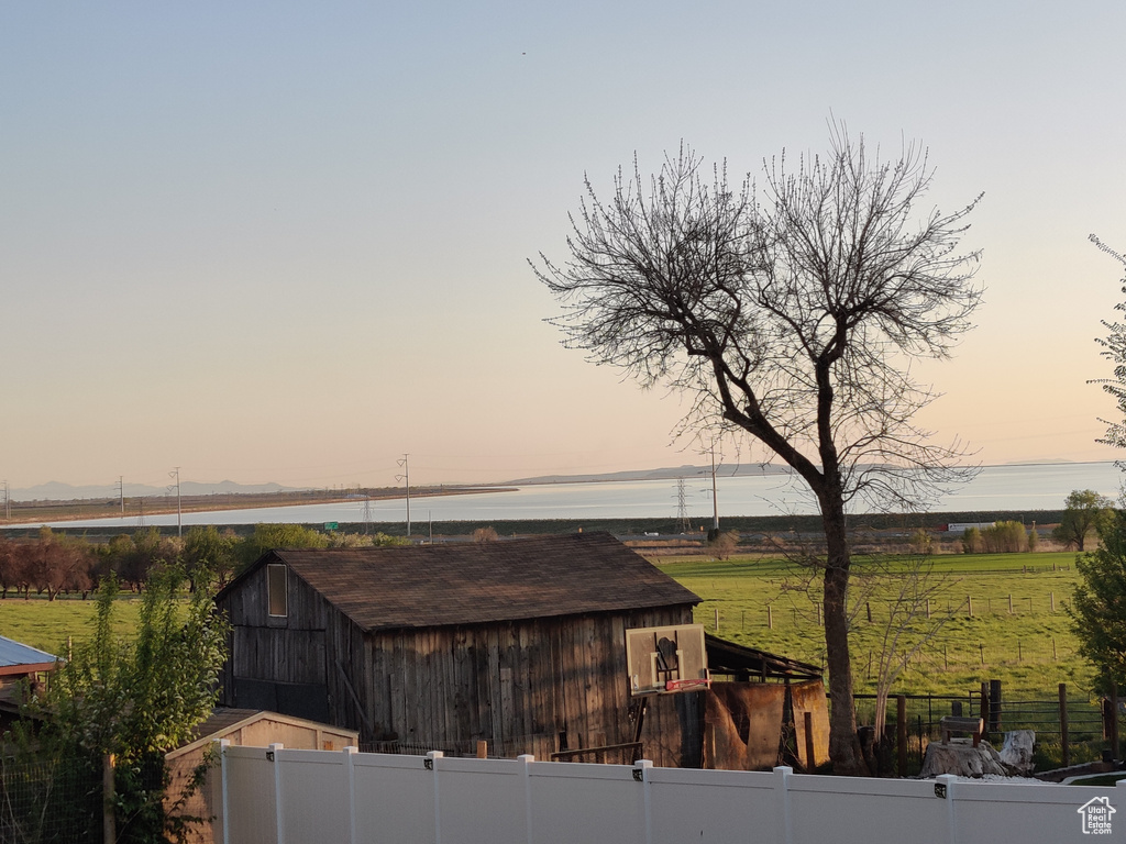Yard at dusk featuring an outbuilding and a barn
