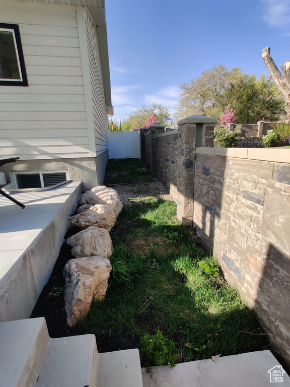 View of property exterior featuring a gate