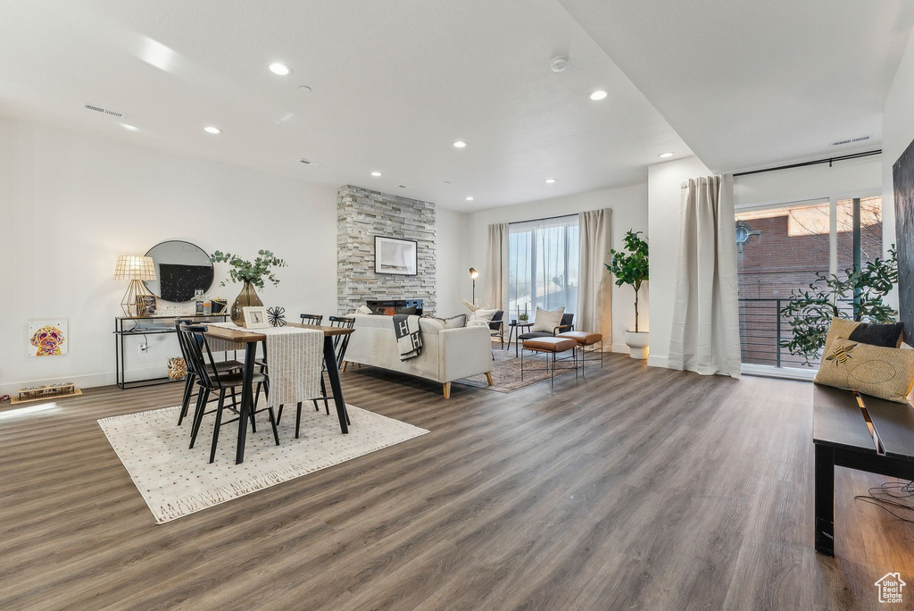 Dining space featuring a stone fireplace and dark wood-type flooring