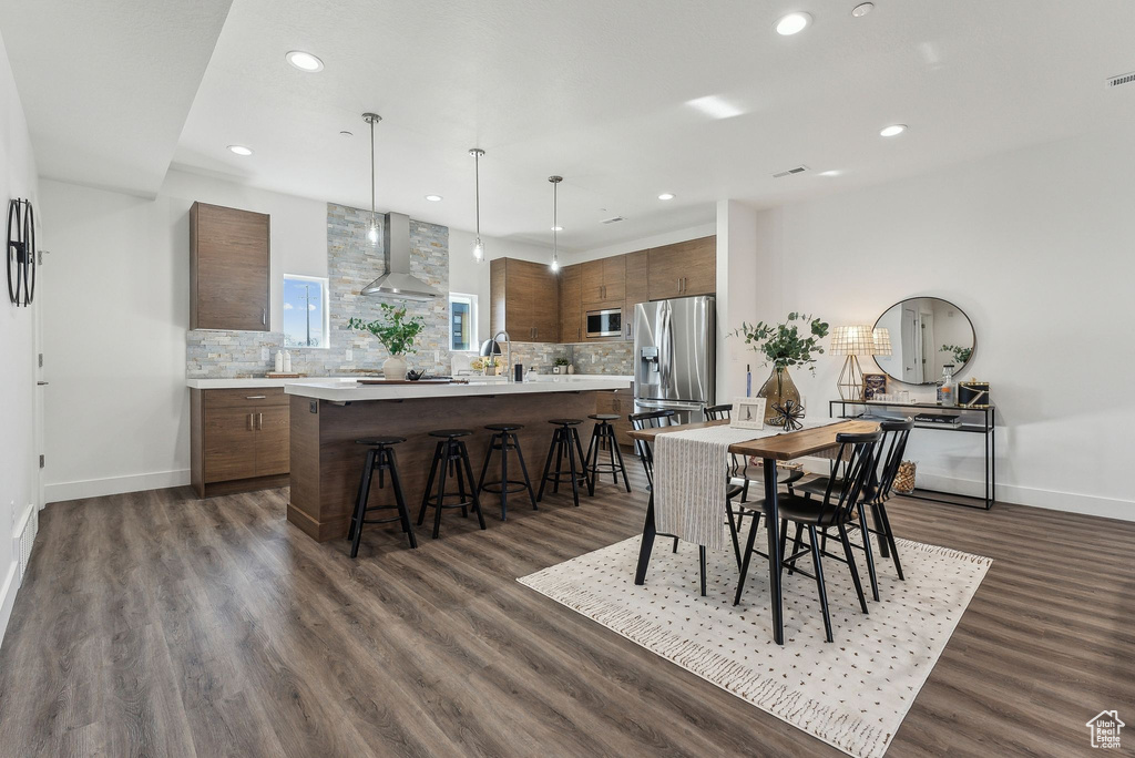 Dining space featuring sink and dark wood-type flooring