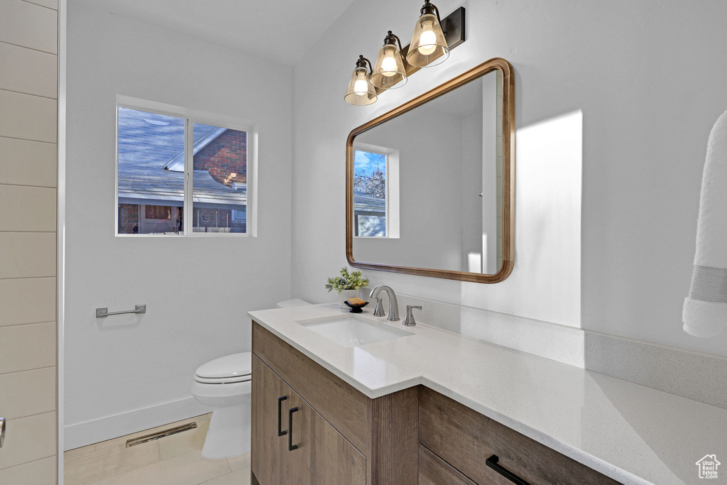 Bathroom featuring vanity, toilet, and tile patterned flooring