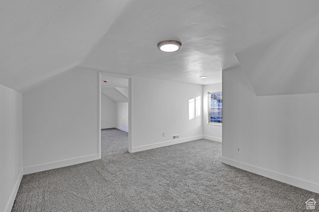 Bonus room featuring carpet floors and vaulted ceiling