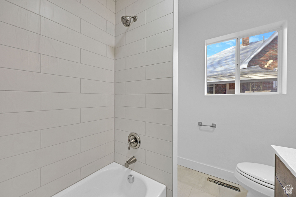 Full bathroom with tile patterned floors, tiled shower / bath combo, vanity, and toilet