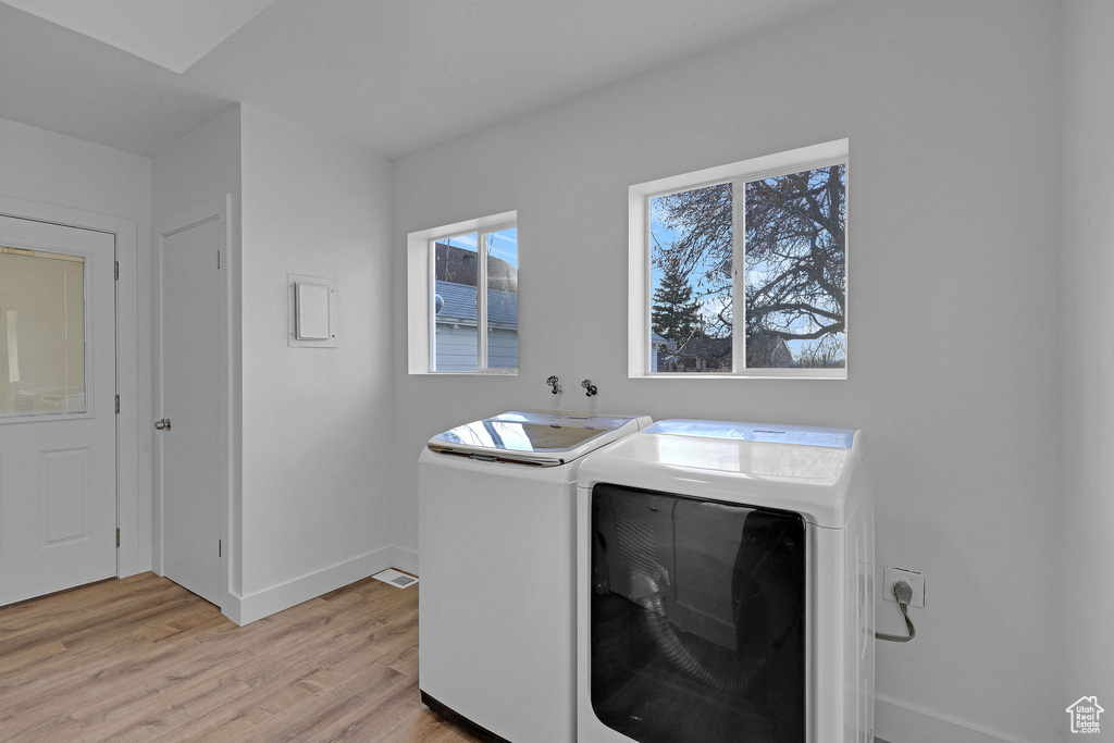 Laundry area with light hardwood / wood-style flooring and independent washer and dryer