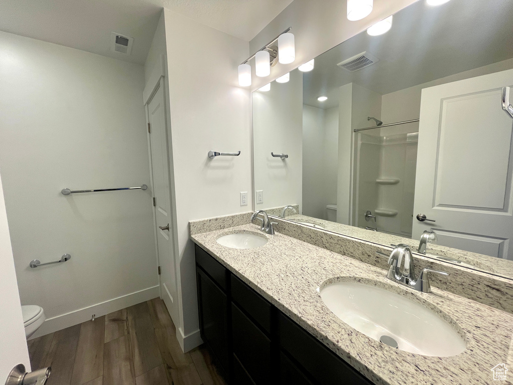 Full bath with visible vents, toilet, and a sink