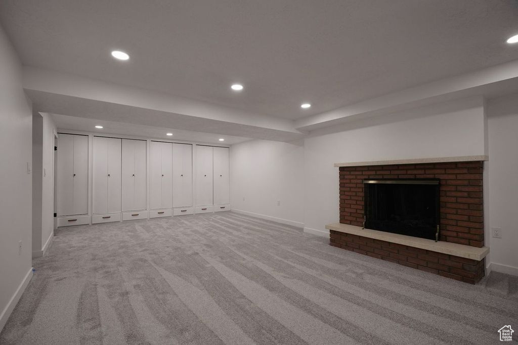 Unfurnished living room with a fireplace and light carpet