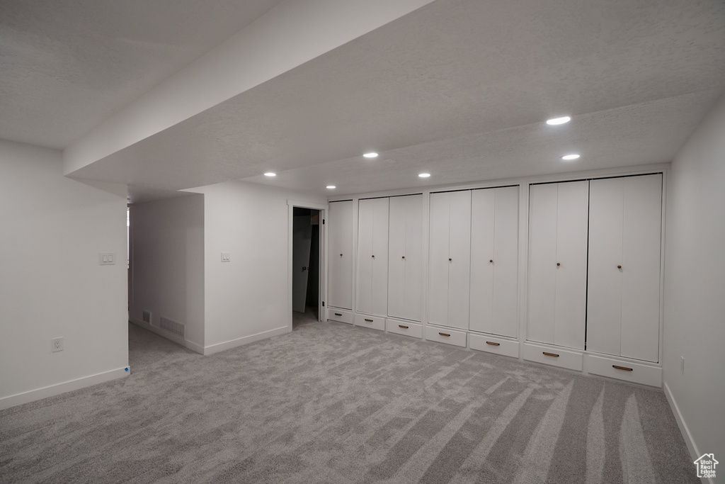 Basement featuring light colored carpet