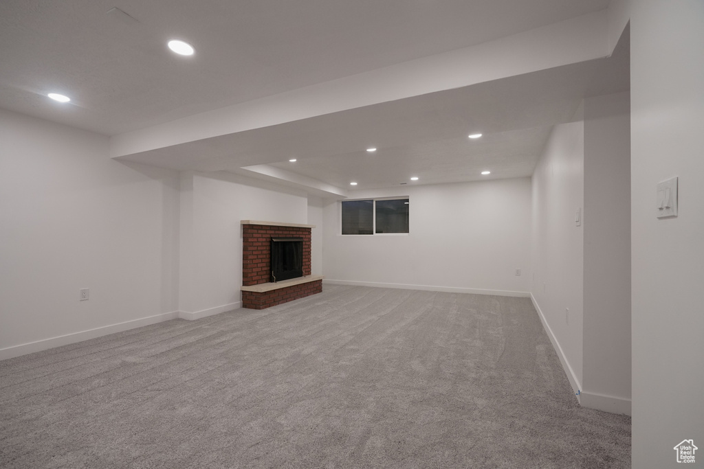 Basement featuring carpet floors and a fireplace