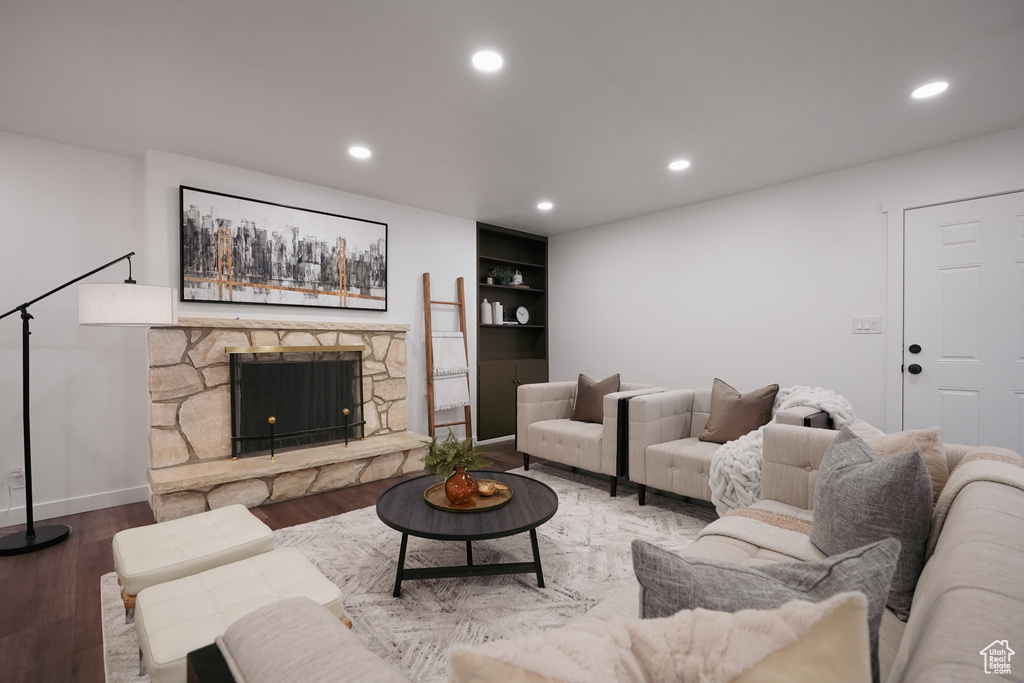 Living room with hardwood / wood-style flooring, a fireplace, and built in shelves