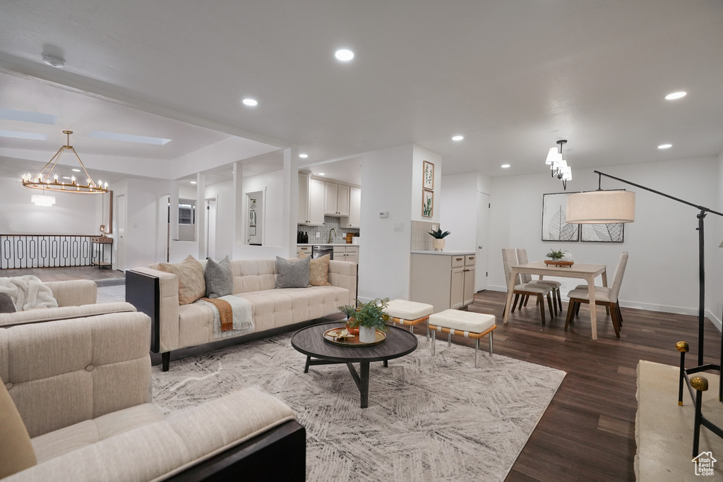 Living room with a notable chandelier and hardwood / wood-style flooring