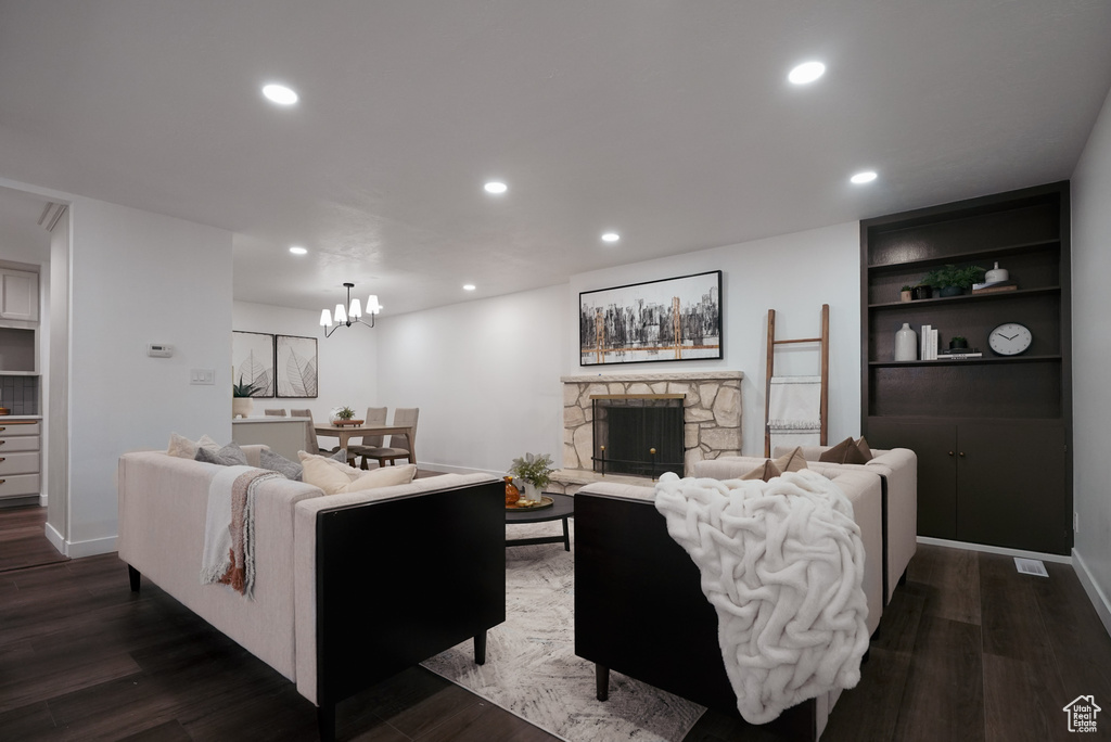 Living room with dark wood-type flooring, a fireplace, and built in features