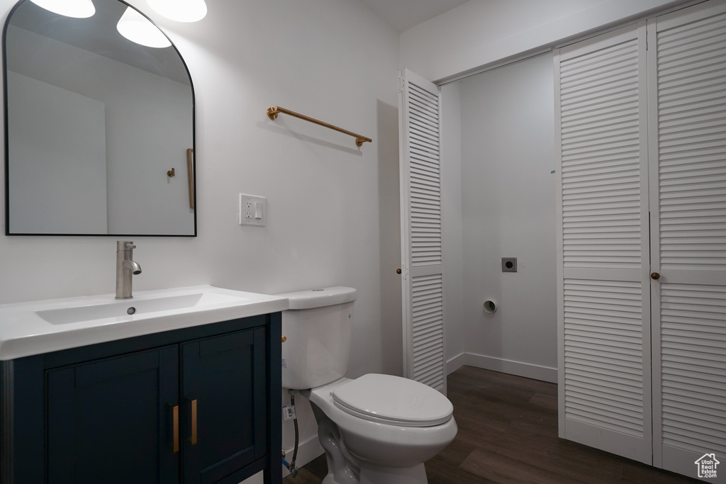 Bathroom with vanity, hardwood / wood-style floors, and toilet