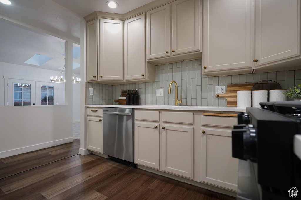 Kitchen with dark wood-type flooring, sink, a skylight, dishwasher, and decorative backsplash