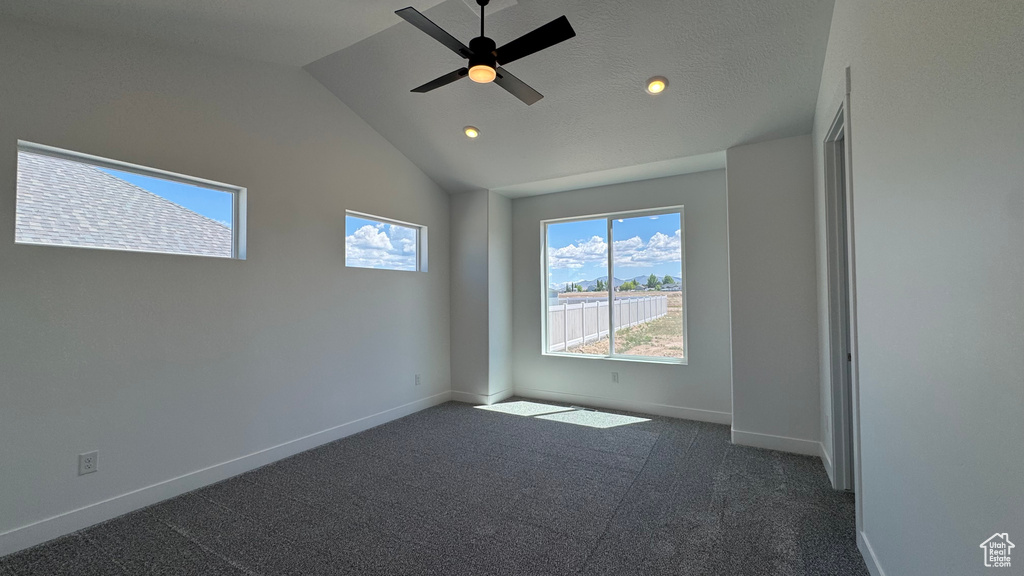 Empty room featuring baseboards, recessed lighting, lofted ceiling, dark carpet, and a ceiling fan