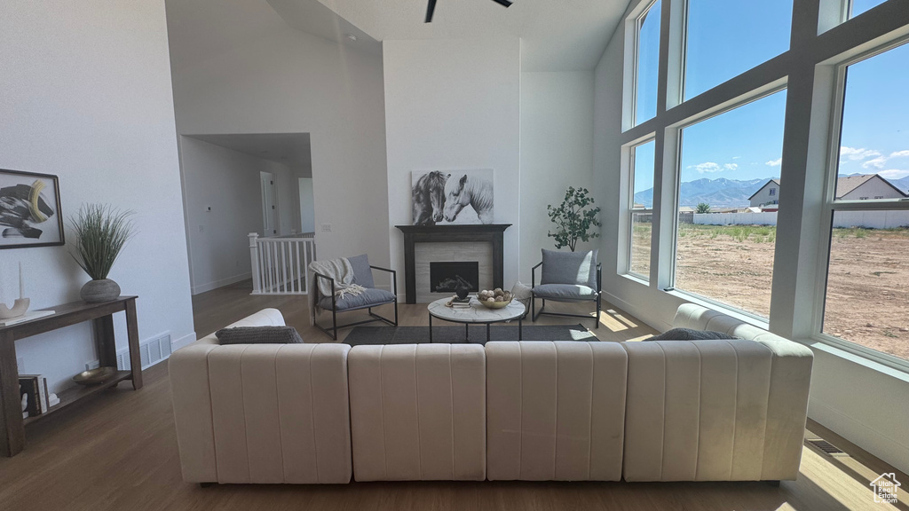 Living area with a towering ceiling, baseboards, healthy amount of natural light, and a fireplace