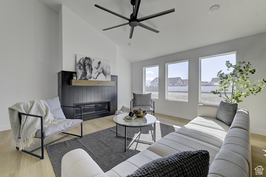 Living room featuring ceiling fan, light hardwood / wood-style flooring, and lofted ceiling