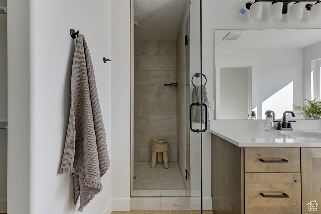 Bathroom featuring vanity and a shower with door