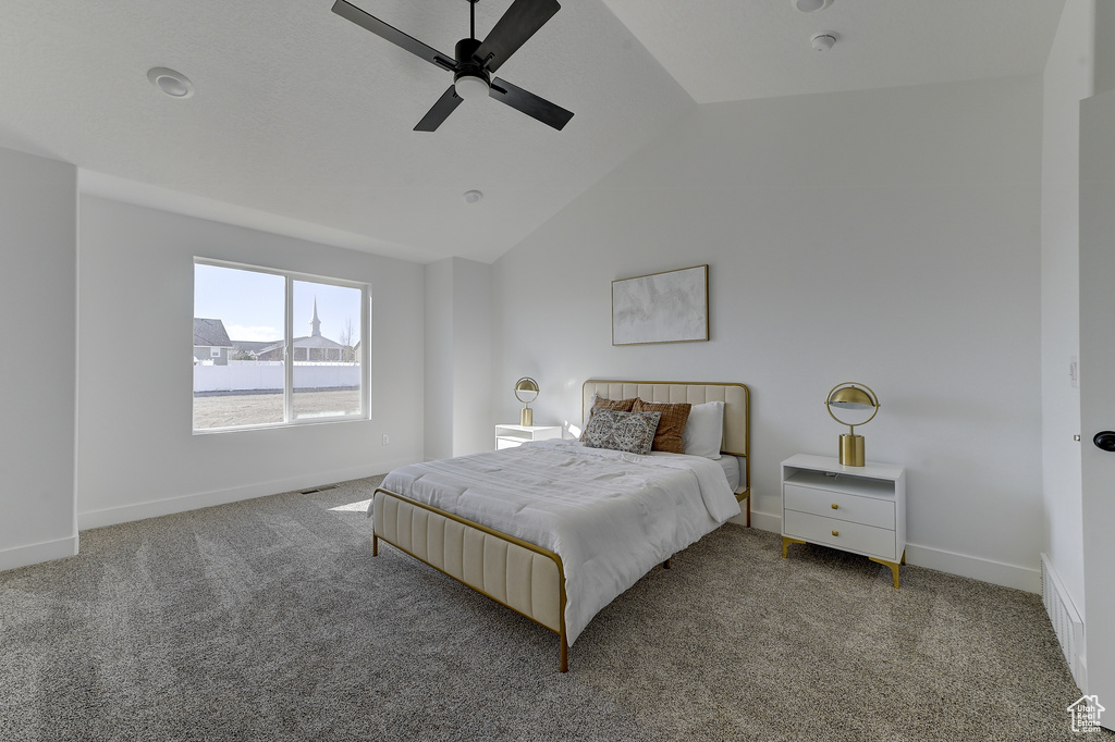 Carpeted bedroom featuring ceiling fan and lofted ceiling