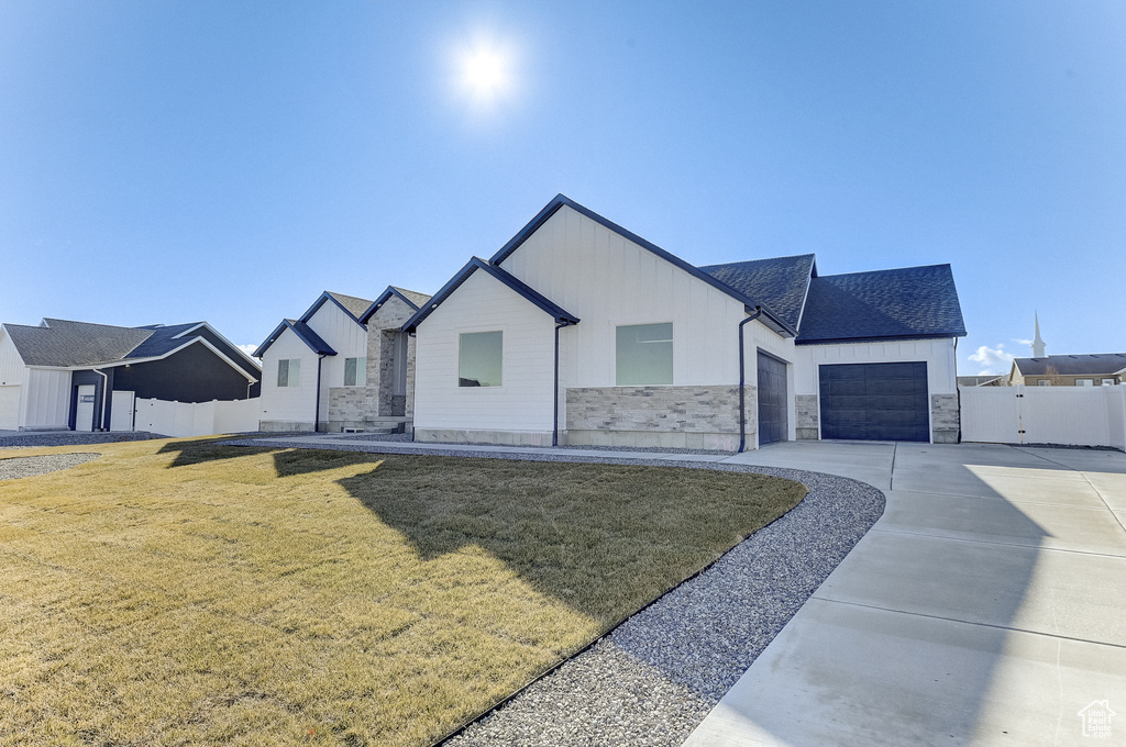 View of front of property featuring a front yard and a garage