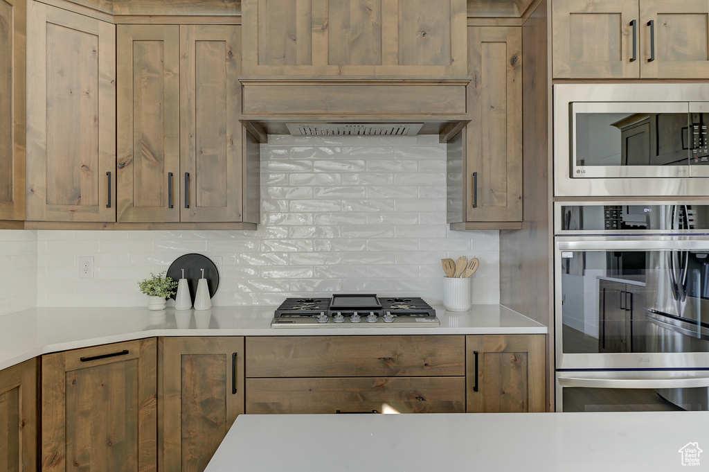 Kitchen featuring decorative backsplash and stainless steel appliances