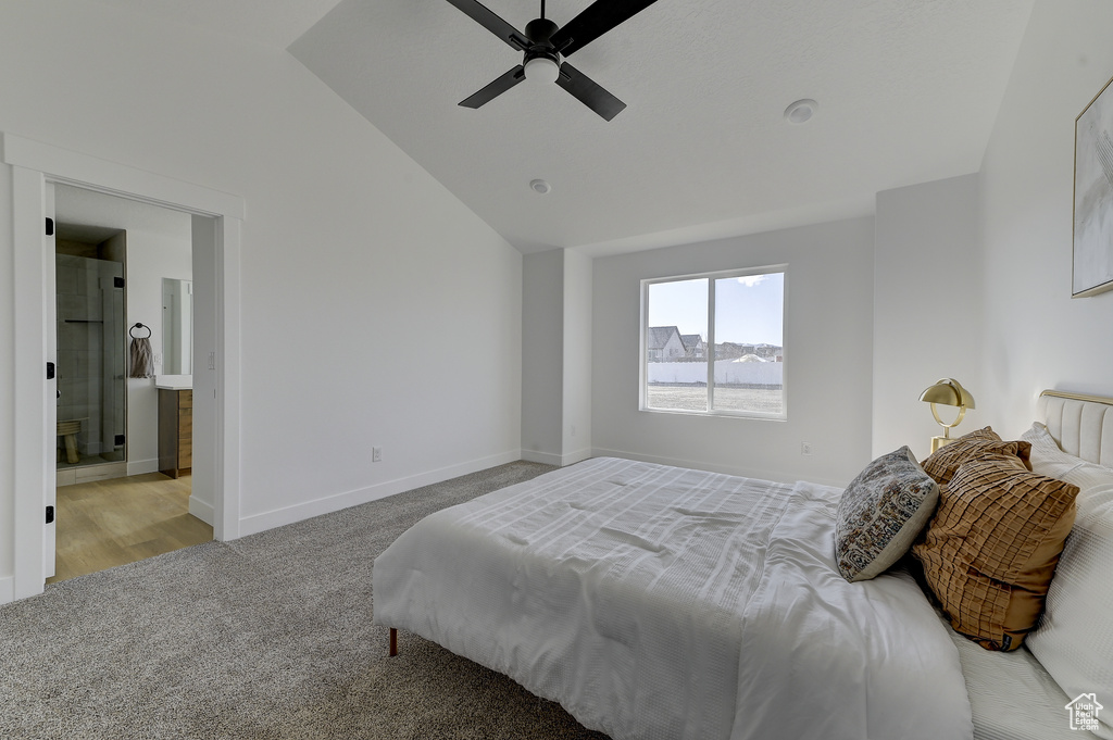 Bedroom featuring light carpet, vaulted ceiling, connected bathroom, and ceiling fan