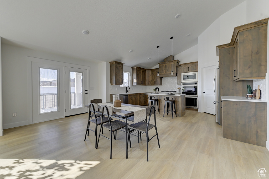 Dining room featuring lofted ceiling and light hardwood / wood-style flooring