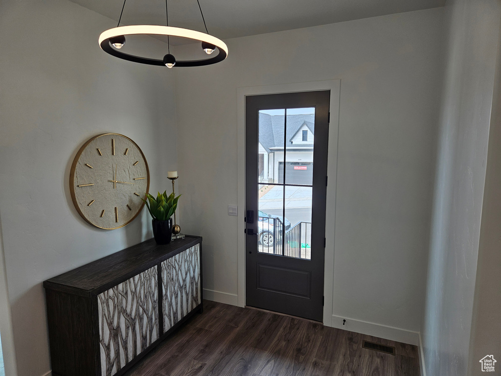 Entrance foyer with dark wood-style flooring and baseboards