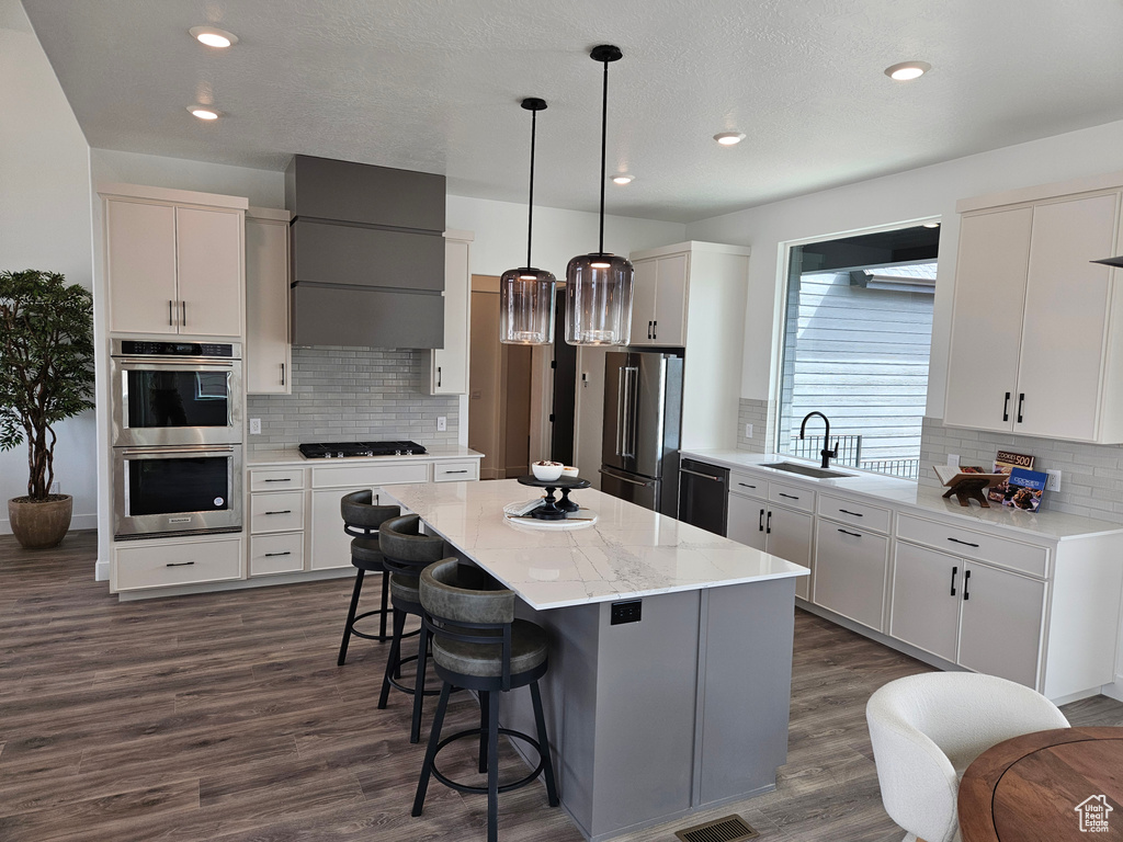 Kitchen featuring black appliances, a sink, backsplash, dark wood-style floors, and recessed lighting