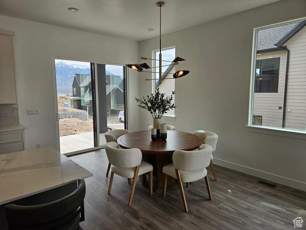 Dining room featuring dark wood-style flooring, baseboards, and recessed lighting