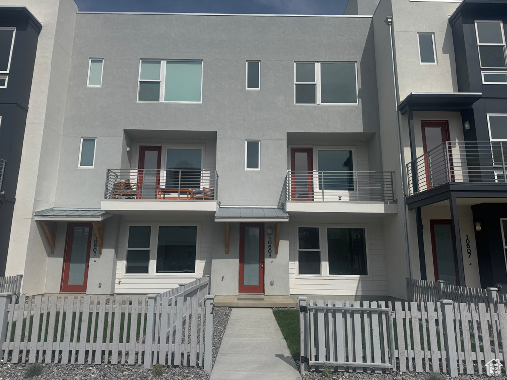 View of front of house with metal roof, stucco siding, a standing seam roof, and a fenced front yard