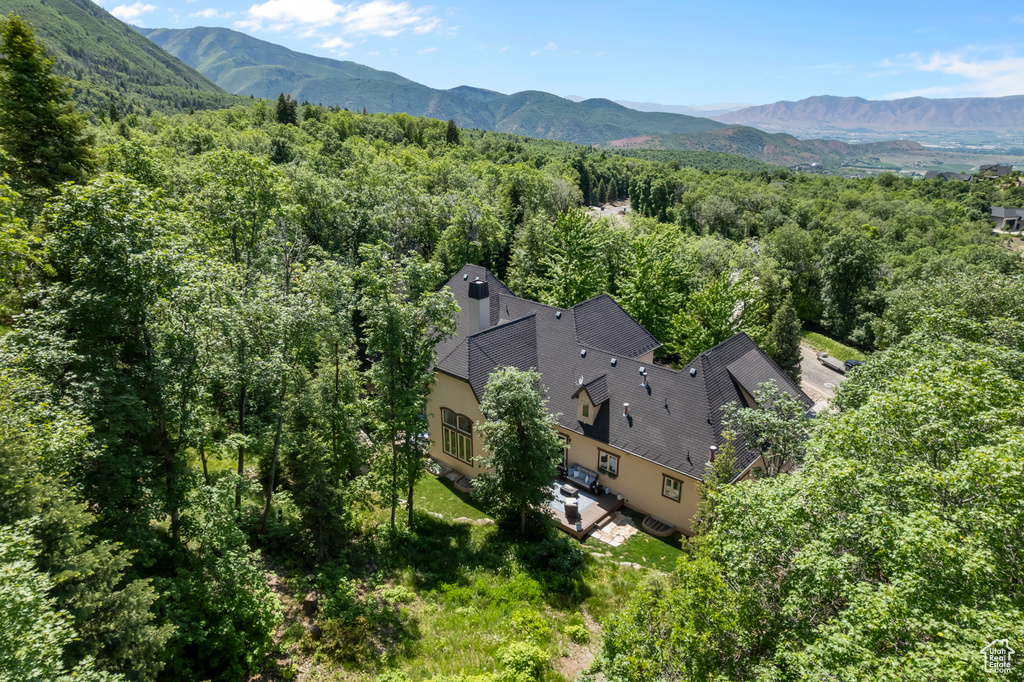 View of subject property featuring a heavily wooded area and a mountainous background
