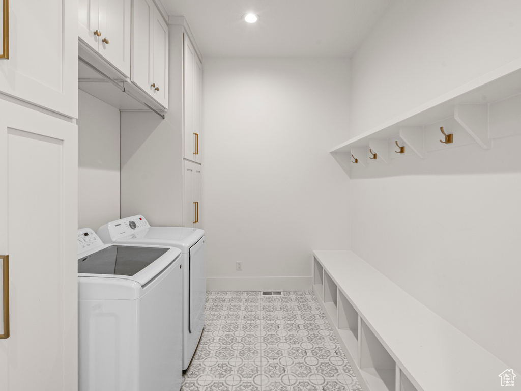 Laundry room featuring cabinets and washer and clothes dryer