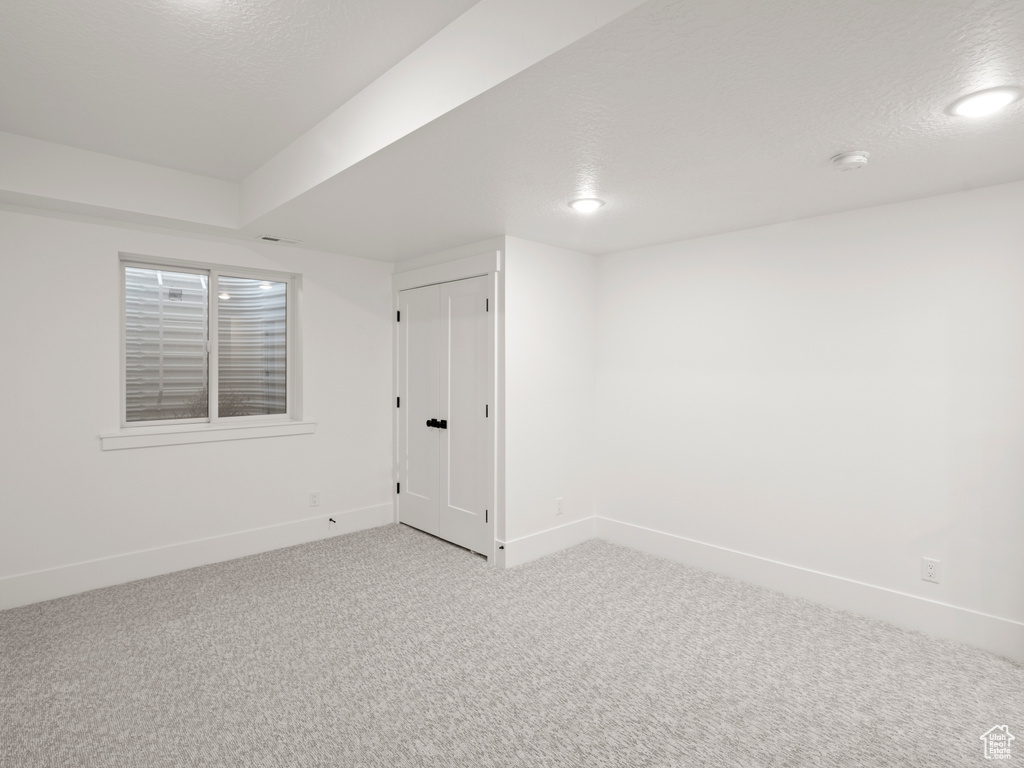 Carpeted spare room with a textured ceiling