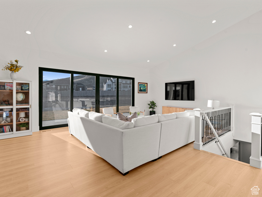 Living room featuring lofted ceiling and light hardwood / wood-style flooring