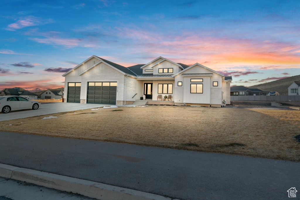 Modern farmhouse style home with a yard, a garage, and a porch