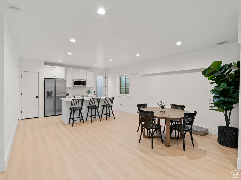 Dining area with light hardwood / wood-style flooring