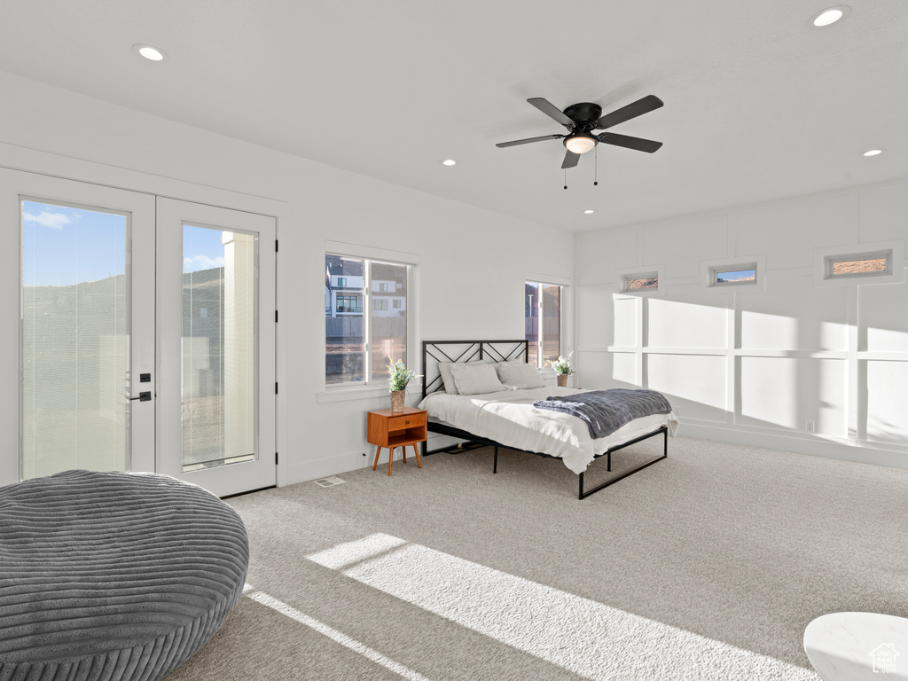 Bedroom featuring light carpet, access to exterior, and ceiling fan