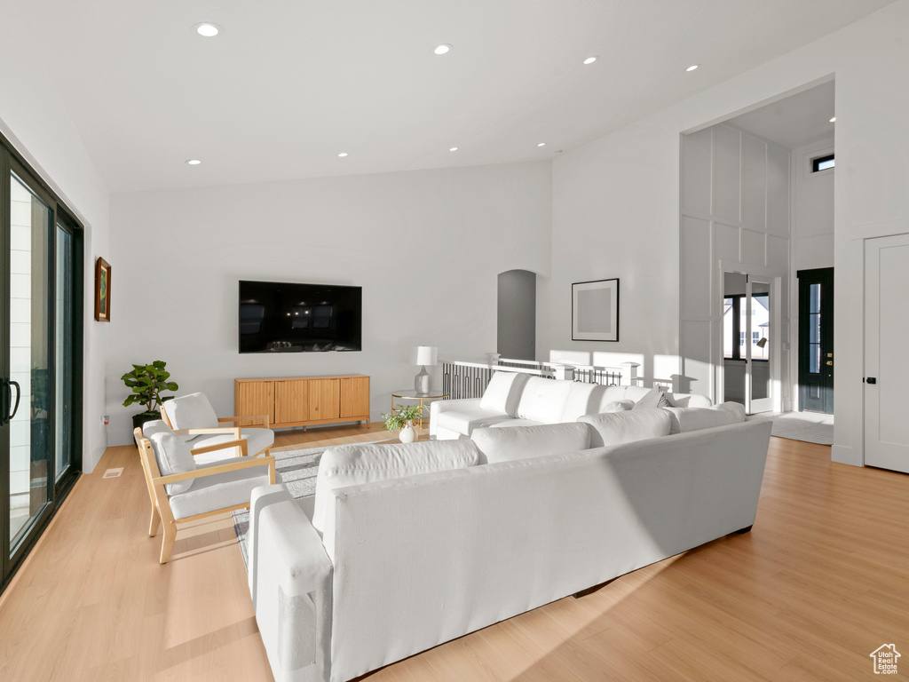 Living room featuring light hardwood / wood-style floors and a high ceiling