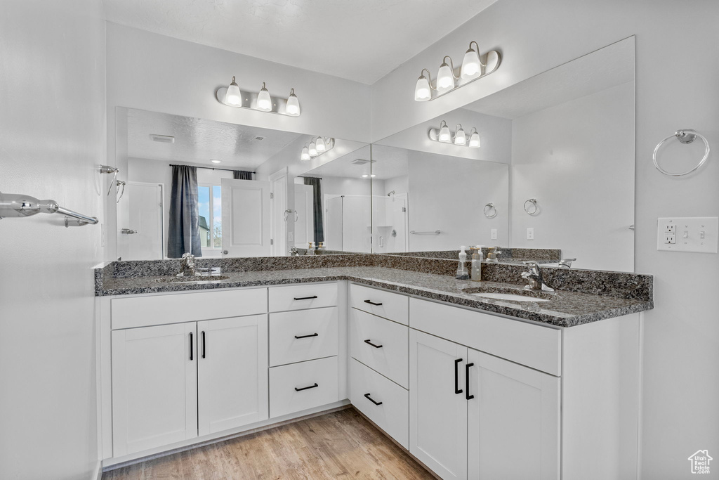 Bathroom featuring vanity, a shower with shower door, and hardwood / wood-style floors